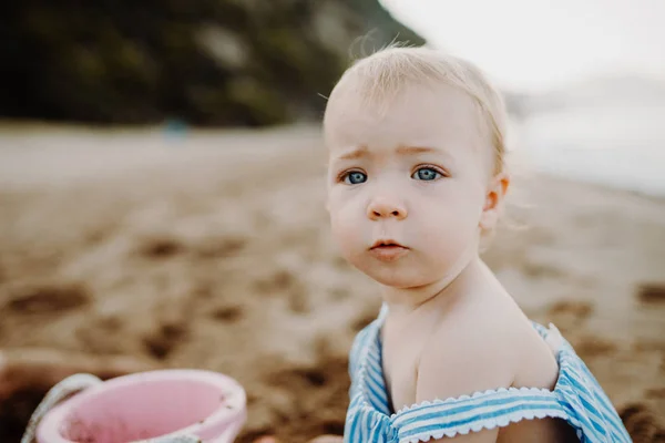Ένα κοντινό πλάνο toddler μικρό κορίτσι στην παραλία στις καλοκαιρινές τους διακοπές, παίζει. — Φωτογραφία Αρχείου