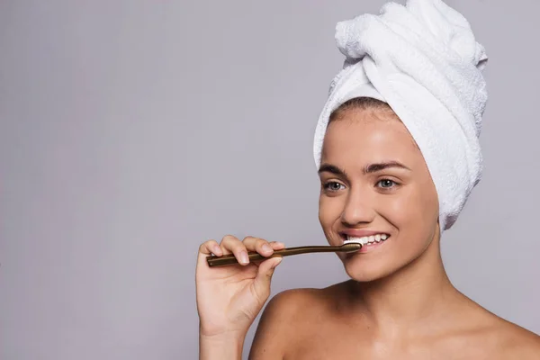 Retrato de una mujer joven cepillándose los dientes en un estudio, belleza y cuidado de la piel . — Foto de Stock