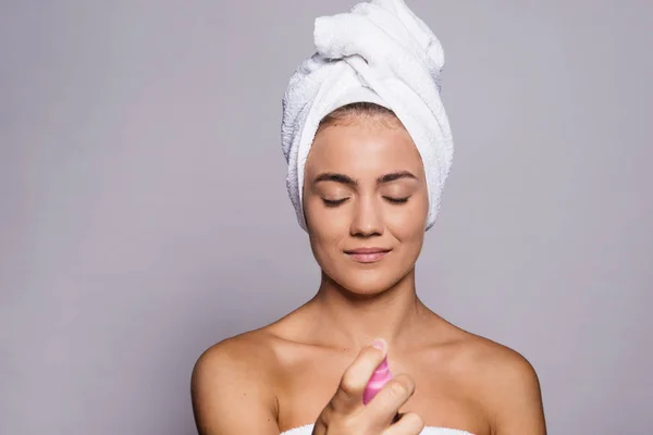 Porträt einer jungen Frau mit Spray im Atelier, Schönheits- und Hautpflege. — Stockfoto