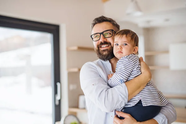 A portrait of father with a toddler girl indoors, hugging. — Stock Photo, Image