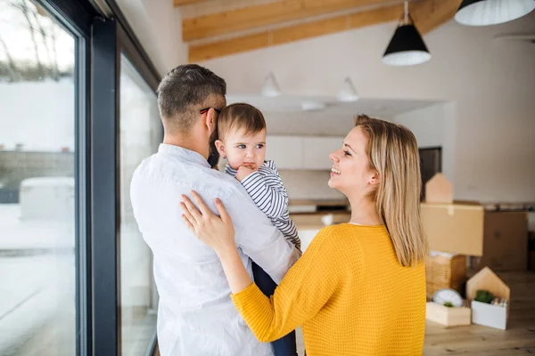 Una familia joven con una niña que se muda a un nuevo hogar . — Foto de Stock