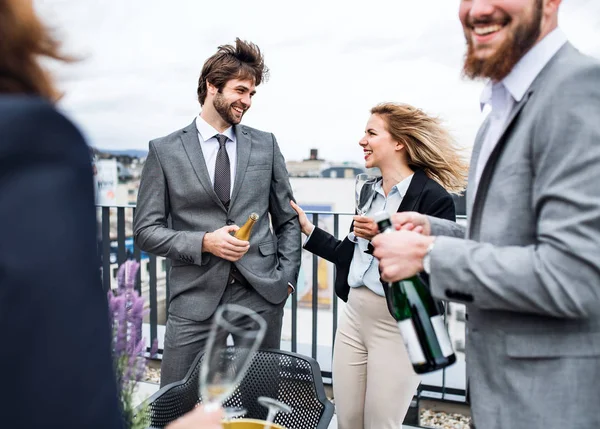 Een groep vrolijke zakenlui die een feestje hebben buiten op het dakterras in de stad. — Stockfoto