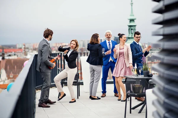 En grupp glada affärsmän som har en fest utomhus på takterrassen i staden. — Stockfoto