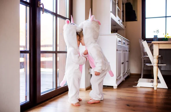 Dwoje dzieci malucha z jednorożcem maski gry w pomieszczeniu w domu. — Zdjęcie stockowe