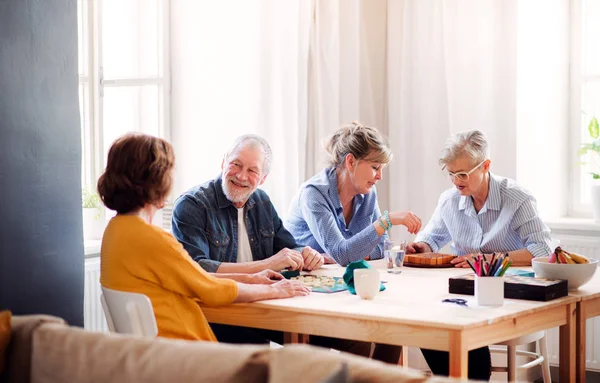 Groupe de personnes âgées jouant à des jeux de société dans le club du centre communautaire . — Photo