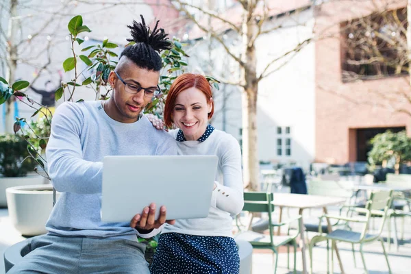 Jóvenes empresarios con portátil en el patio, concepto de puesta en marcha . — Foto de Stock