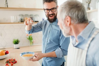 Yetişkin bir hipster oğlu ve evde üst düzey baba, yemek.
