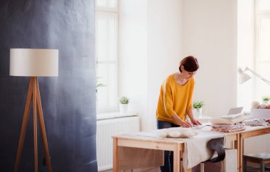 Genç yaratıcı kadın bir stüdyoda küçük terzilik iş başlangıç.