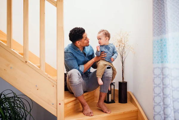 Un retrato de padre e hijo pequeño en casa, sentado en la escalera . —  Fotos de Stock