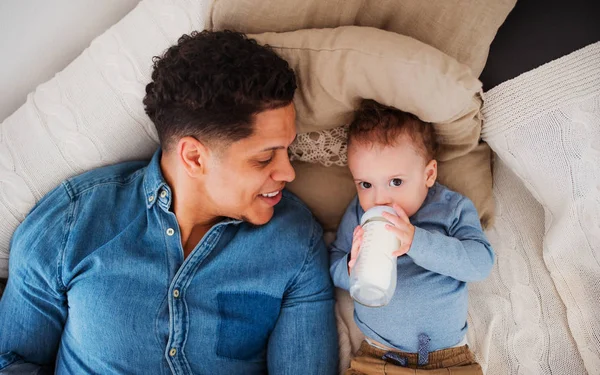 Una vista superior del padre y un hijo en casa, bebiendo leche de la botella . —  Fotos de Stock