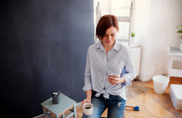 A portrait of young woman painting wall black. A startup of small business. — Stock Photo, Image