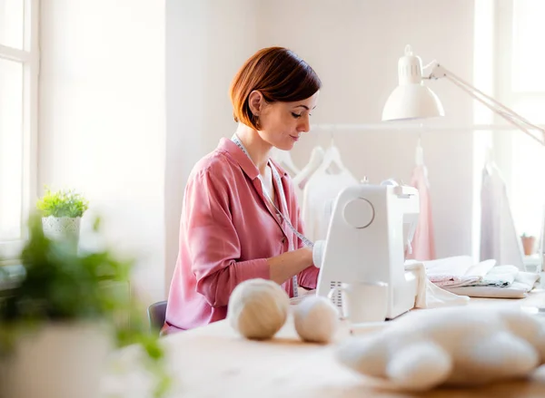 Joven mujer creativa en un estudio, trabajando. Una puesta en marcha de negocio de sastrería . —  Fotos de Stock