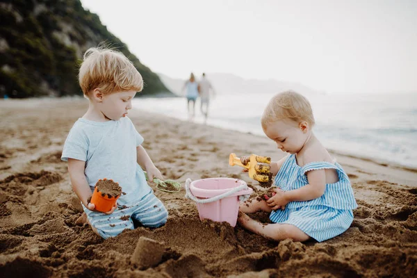 Dos niños pequeños jugando en la playa de arena en vacaciones de verano . —  Fotos de Stock