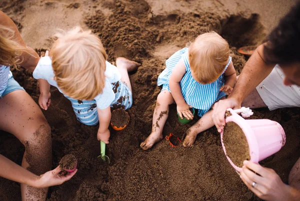 Midsection de la famille avec des enfants en bas âge jouant sur la plage pendant les vacances d'été . — Photo