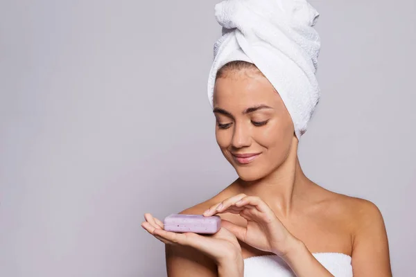 Un retrato de mujer joven con una barra de jabón en un estudio, belleza y cuidado de la piel . — Foto de Stock