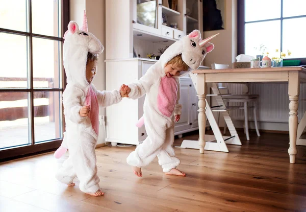 Two toddler children with unicorn masks playing indoors at home. — Stock Photo, Image