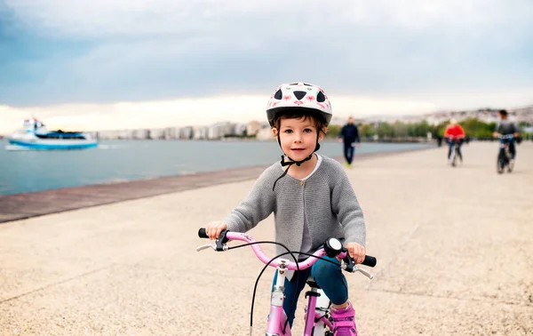 ビーチで自転車でサイクリングをする小さな女の子. — ストック写真
