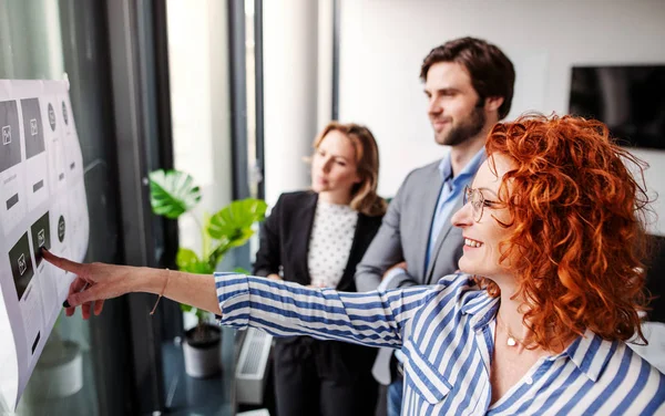 A group of young business people in an office, brainstorming. — Stock Photo, Image