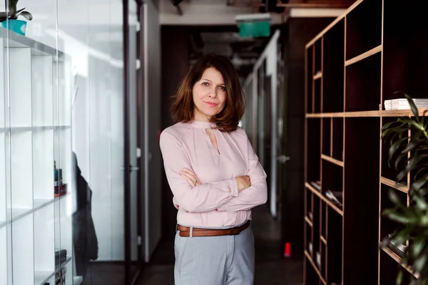 Um retrato de mulher de negócios em pé em um prédio de escritórios, olhando para a câmera . — Fotografia de Stock