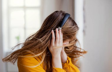 Eğleniyor kulaklıklı genç bir kız öğrenci.