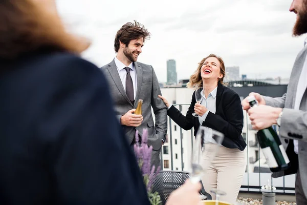 En grupp glada affärsmän som har en fest utomhus på takterrassen i staden. — Stockfoto