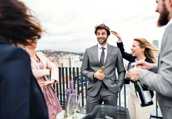 Un groupe d'hommes d'affaires joyeux faisant une fête à l'extérieur sur la terrasse du toit en ville . — Photo