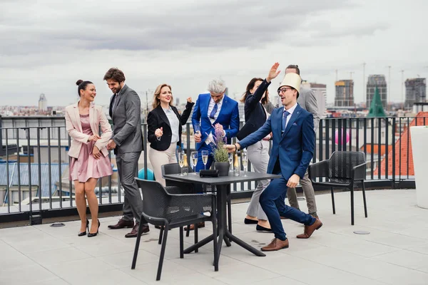 Un gruppo di uomini d'affari gioiosi che fanno una festa all'aperto sulla terrazza sul tetto della città . — Foto Stock