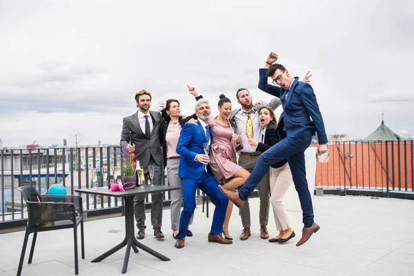 Un grupo de empresarios alegres haciendo una fiesta al aire libre en la azotea de la ciudad . —  Fotos de Stock