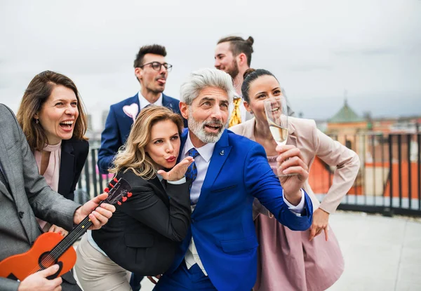 En grupp glada affärsmän som har en fest utomhus på takterrassen i staden. — Stockfoto