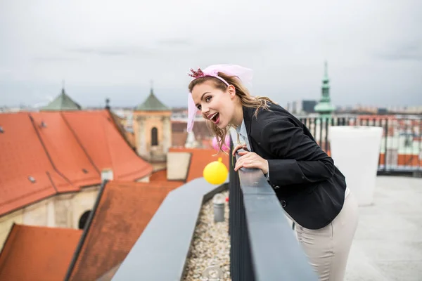 Une femme avec bandeau princesse sur la fête à l'extérieur sur la terrasse sur le toit en ville . — Photo