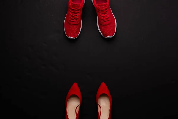 Uno scatto in studio di un paio di scarpe running vs tacco alto su sfondo nero. Posa piatta . — Foto Stock