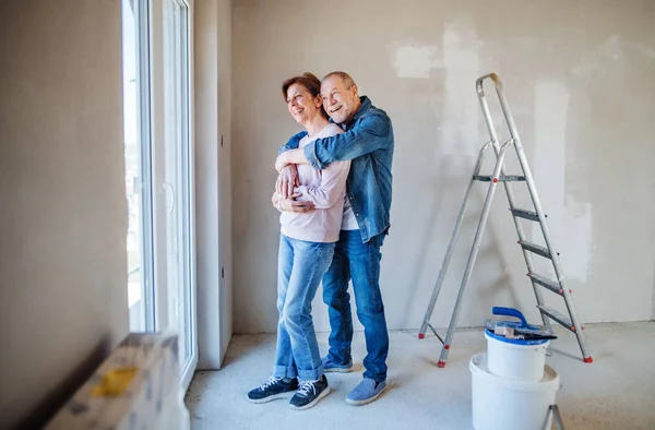 Ένα ζευγάρι που ζωγραφίζει τοίχους σε νέο σπίτι, ξεκουράζεται. Έννοια της μετεγκατάστασης. — Φωτογραφία Αρχείου