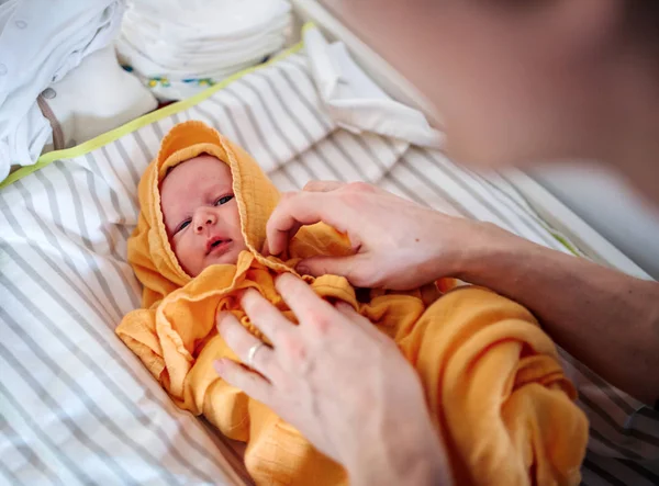 Pai irreconhecível secando um bebê recém-nascido com uma toalha após o banho em casa . — Fotografia de Stock