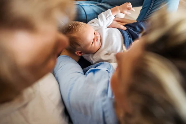 Vista superior de padres jóvenes con un bebé recién nacido en casa . —  Fotos de Stock