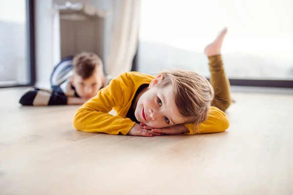 两个快乐的孩子躺在家里的地板上. — 图库照片