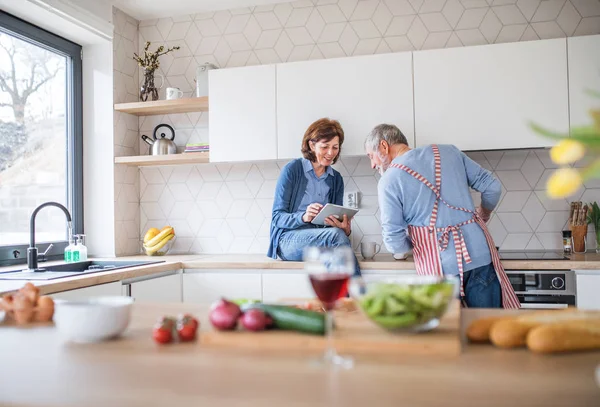 Ett porträtt av Senior par kär inomhus hemma, med hjälp av Tablet. — Stockfoto