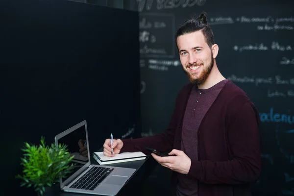 Ung affärsman med laptop i kontor, arbetar. — Stockfoto