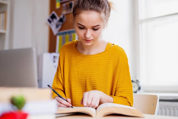Молодая студентка, сидящая за столом, учится . — стоковое фото