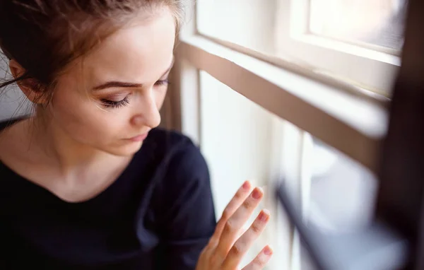 Un primer plano de la joven estudiante triste sentada en el alféizar de la ventana . — Foto de Stock