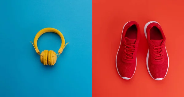 Eine Studioaufnahme von Laufschuhen und Kopfhörern auf farbigem Hintergrund. flache Lage. — Stockfoto