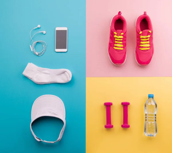 Un colpo di studio di scarpe da corsa e altre attrezzature sportive su sfondo a colori . — Foto Stock
