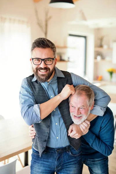 Um filho hipster adulto e pai sênior em casa, se divertindo . — Fotografia de Stock