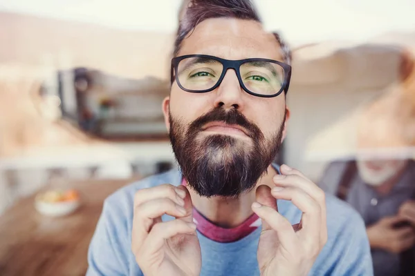 Een portret van een man die binnenshuis thuis staat, neergeschoten door glas. — Stockfoto