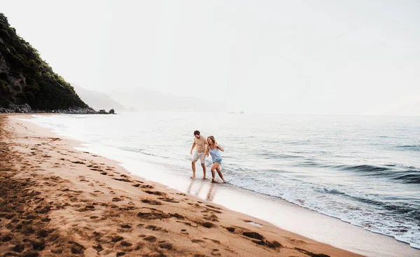 Un hombre y una mujer alegres caminando en la playa en las vacaciones de verano. Copiar espacio . —  Fotos de Stock