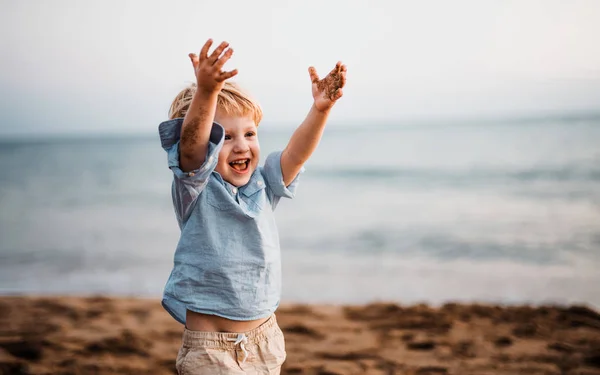 Chłopiec drobny, stojąc na plaży na letnie wakacje, zabawy. — Zdjęcie stockowe
