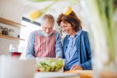 Evde, yemek iç lerinde aşık üst düzey çiftin bir portresi.