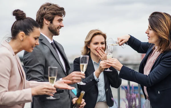 Un grupo de empresarios alegres haciendo una fiesta al aire libre en la azotea de la ciudad . —  Fotos de Stock