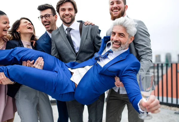 Een groep vrolijke zakenlui die een feestje hebben buiten op het dakterras in de stad. — Stockfoto