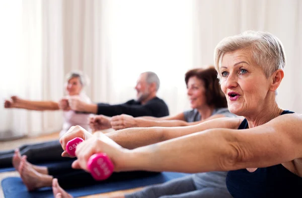 Groep ouderen doen oefening met dumbbells in Community Center Club. — Stockfoto