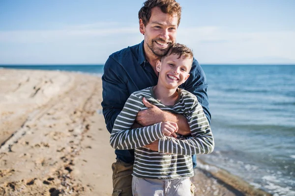 Padre con hijo pequeño en un paseo al aire libre en la playa, divertirse . — Foto de Stock